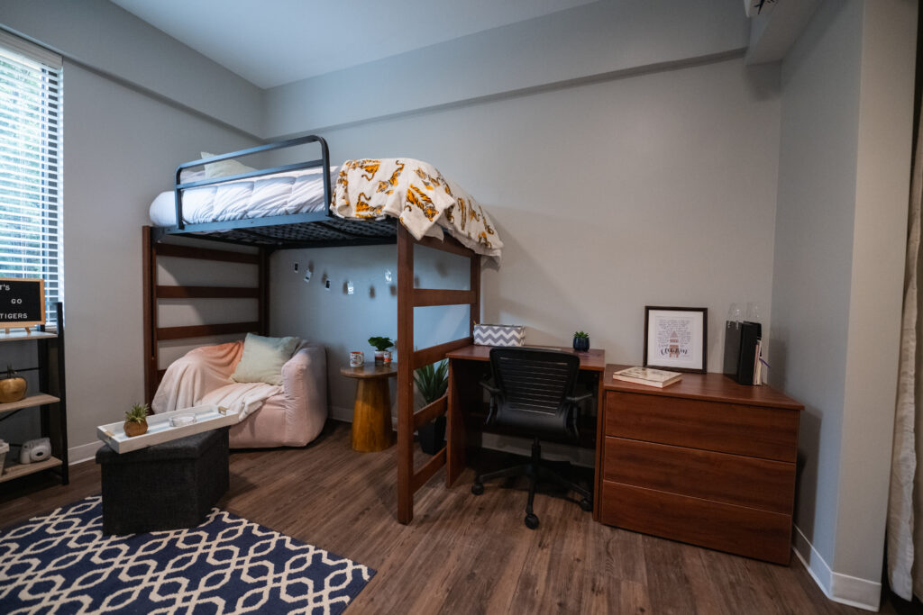 Lofted bed with seat underneath. Desk and drawers next to desk.