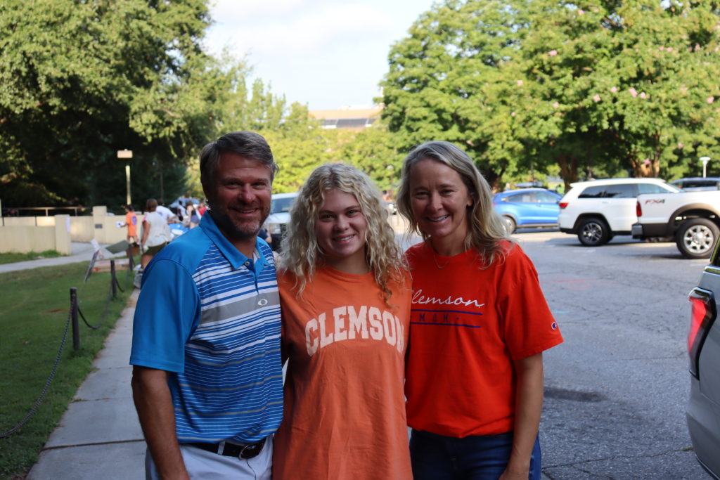 Parents posing with daughter at move-in