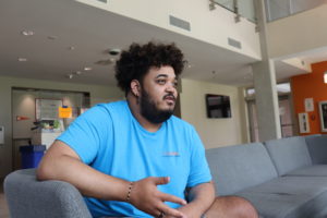 Student residential staff member sitting on couch in residence hall talking