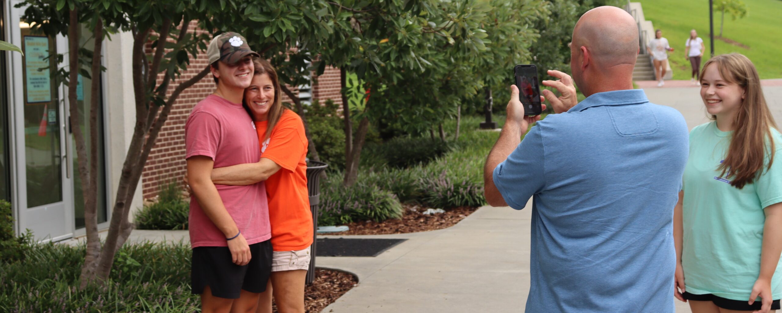 Father taking photo of son with his mother at move-in