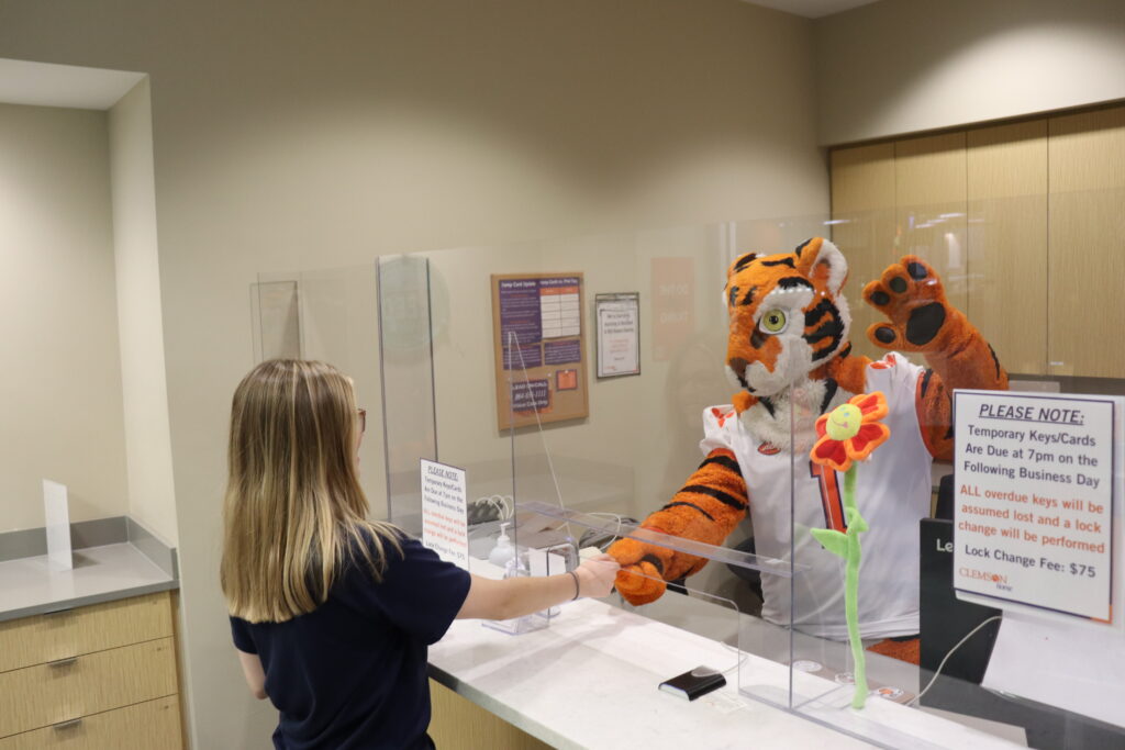 Tiger and student interacting at front desk